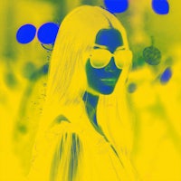 a photo of a woman with sunglasses and a yellow background